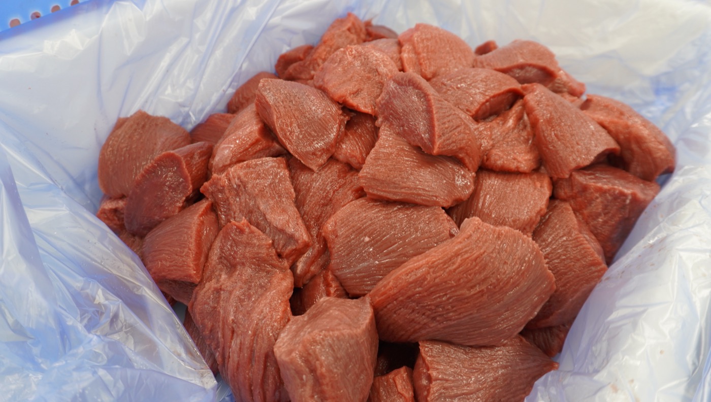 ひと口大にカットされたたん先の赤身肉を、袋を敷いた容器にまとめたところ