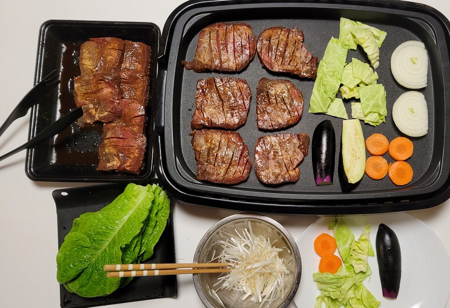 ホットプレートで焼いている牛たんと、キャベツ・玉ねぎ・なす・ズッキーニ・にんじん。手前にレタスと白髪ねぎ