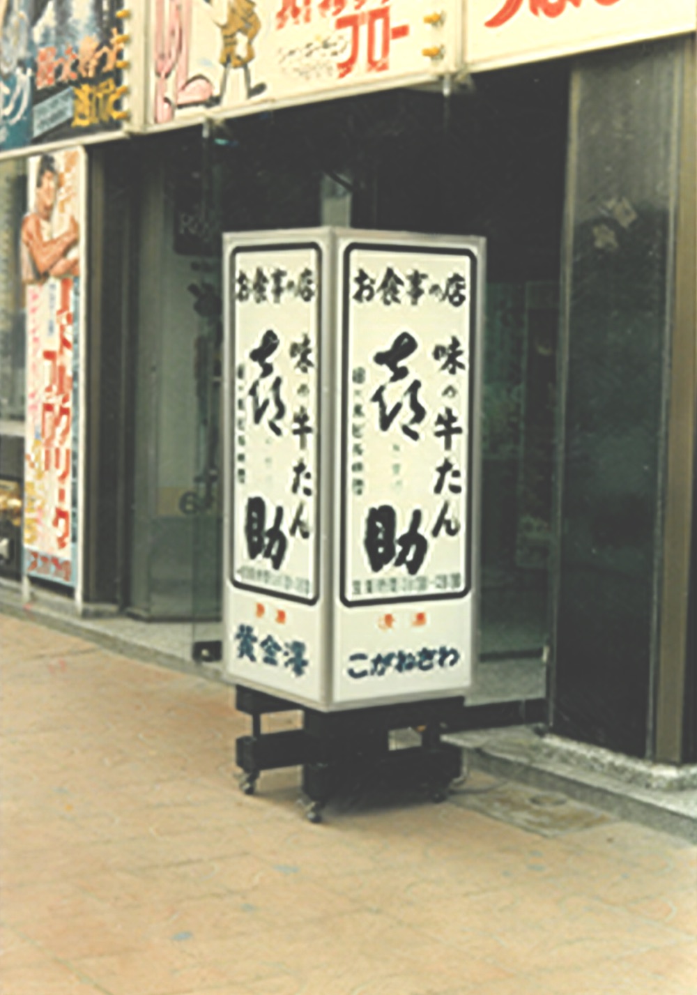 「お食事の店 味の牛たん 喜助」と筆文字で書かれた駅前店の立て看板（1980年）