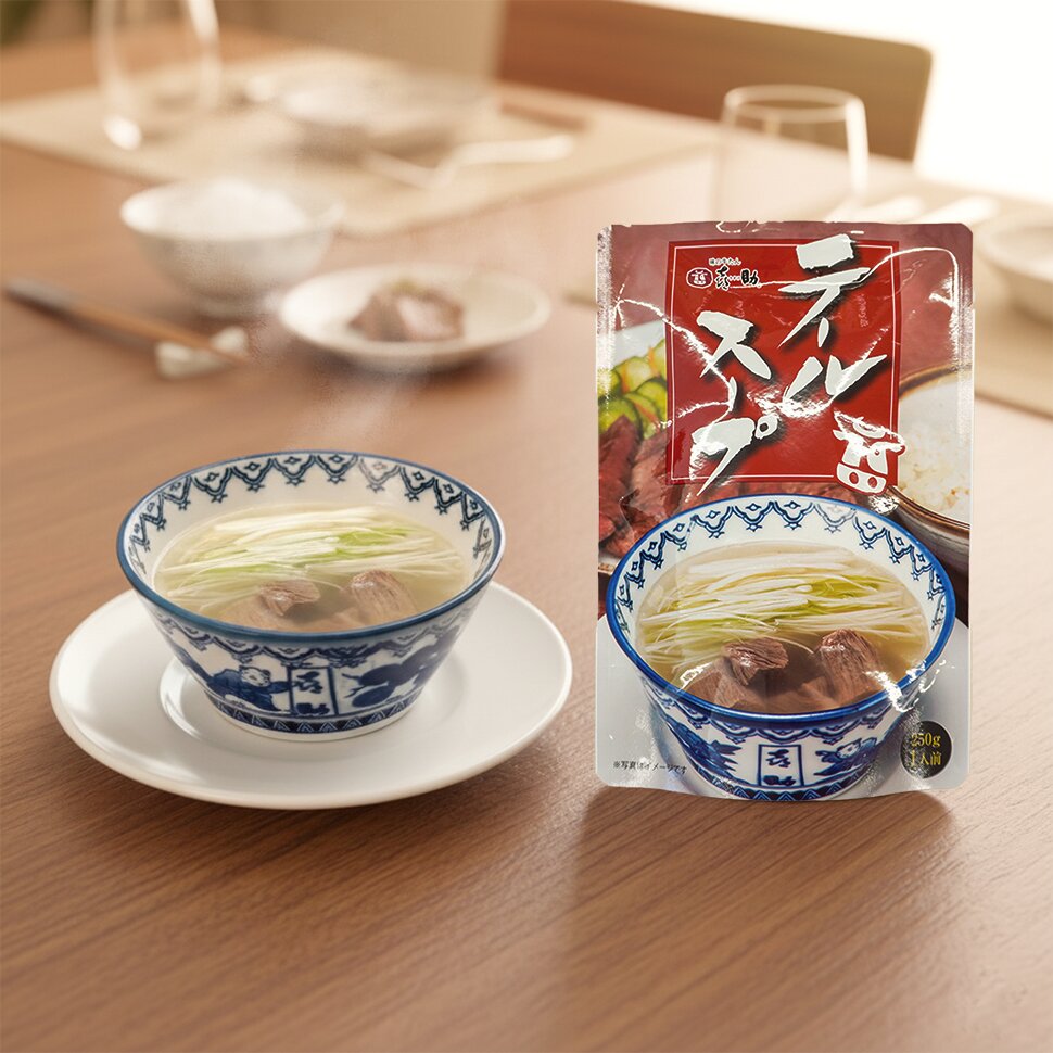 染付の碗に注いだテールスープ。白髪ねぎが浮かび、牛たんが入っている