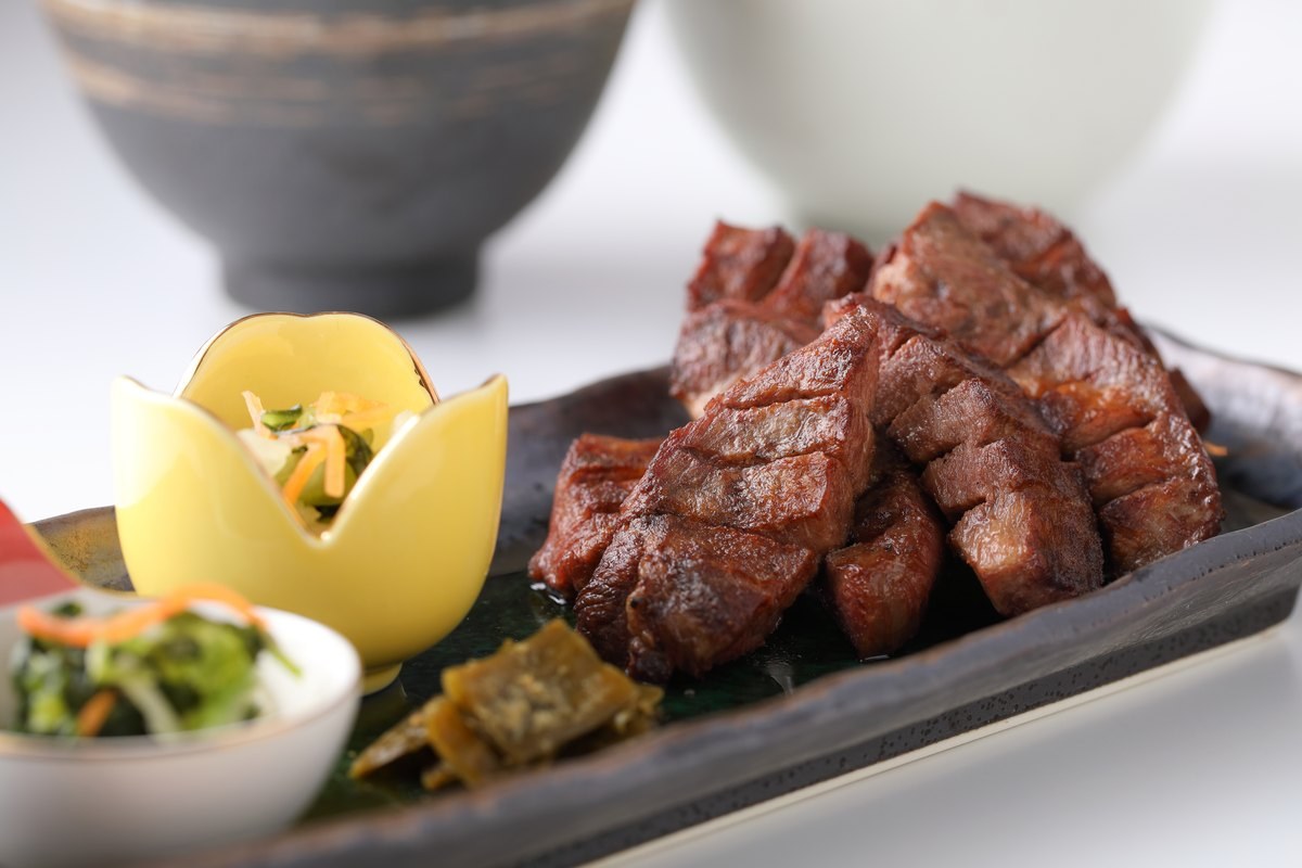 喜助の15㍉牛たん本気盛り定食（２枚６切 4,565円・2026年8月時点の仙台富谷店価格）。厚さ15ミリの牛たん焼きを黒い角皿に盛り、みそ南蛮と小鉢を添えている