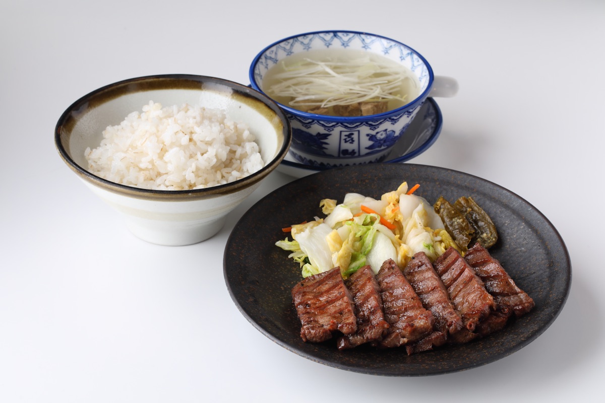 特切り厚焼定食（３枚６切 4,213円・2026年8月時点の駅前中央本店価格）。厚切りの牛たん焼きを黒い皿に盛り、麦飯とテールスープが並んでいる